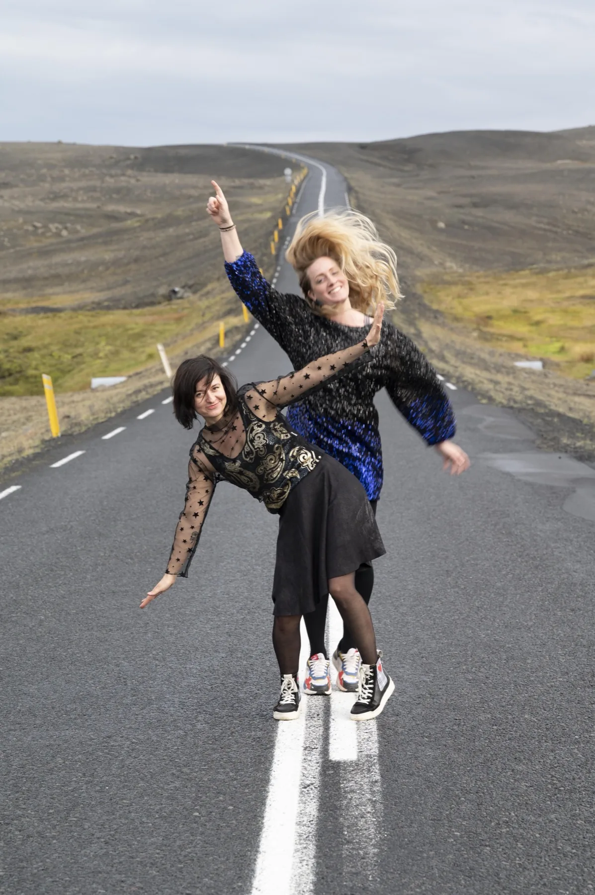 Anne und Sibille auf einer leeren Straße in der isländischen Landschaft