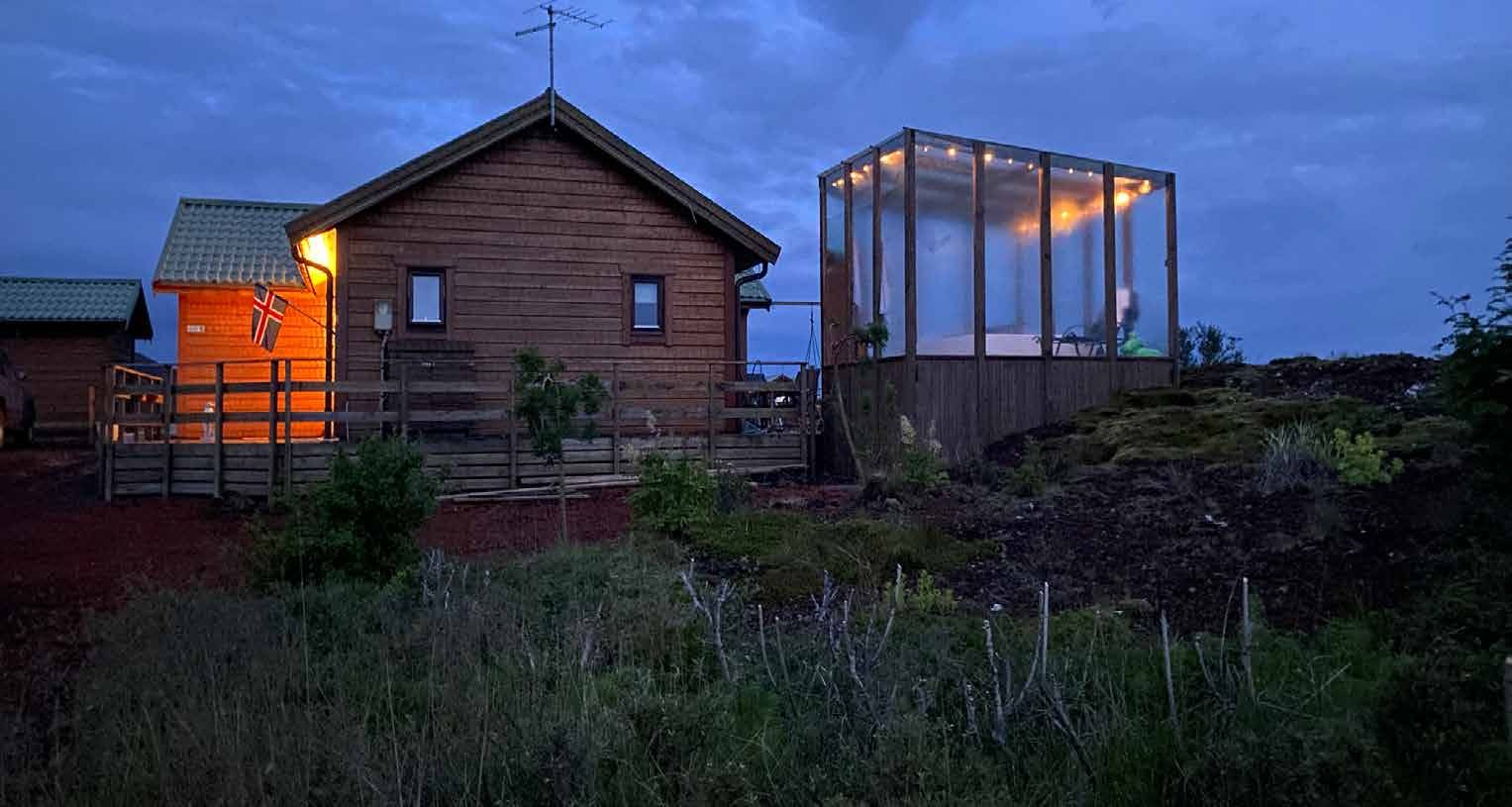 Das Retreat-Haus in Island in der blauen Stunde, daneben der beleuchtete Hot Tub