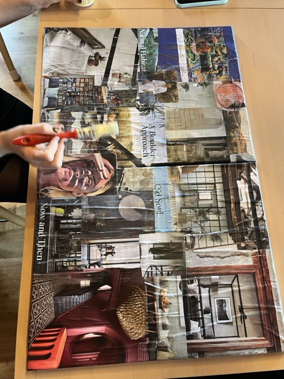 Eine Hand mit Marker über einer entstehenden Bildcollage aus ausgeschnittenen Fotos und Schriftzügen