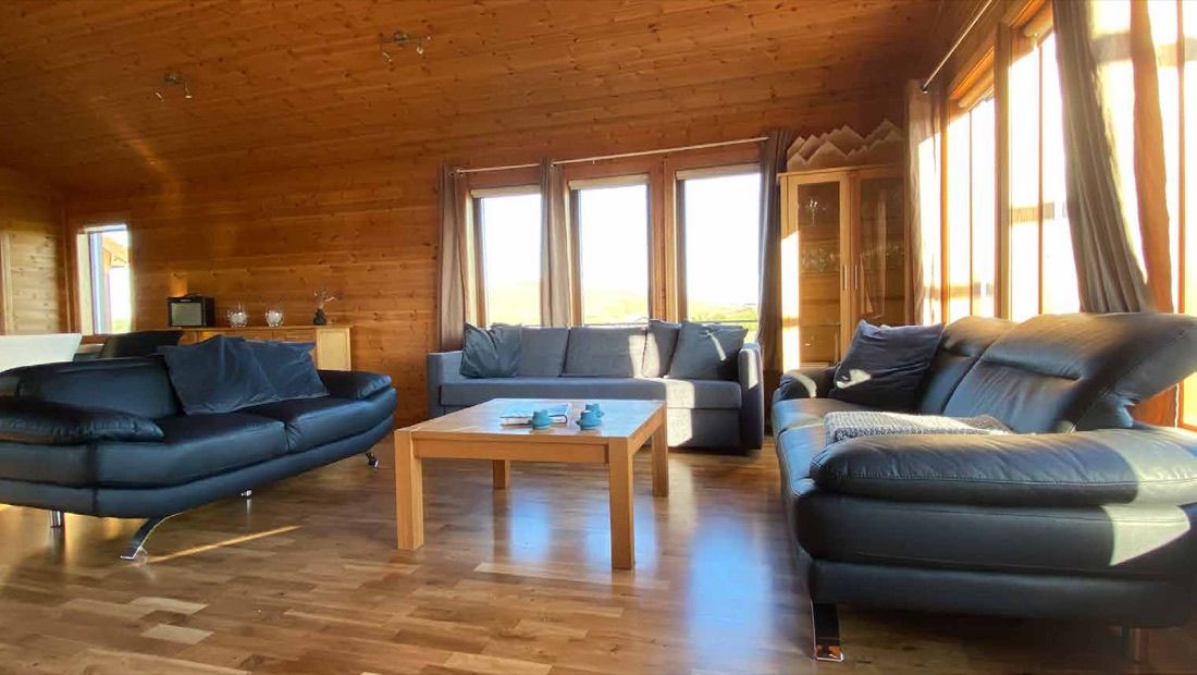 Das Wohnzimmer mit drei Sofas und großen Fenstern zur isländischen Ebene
